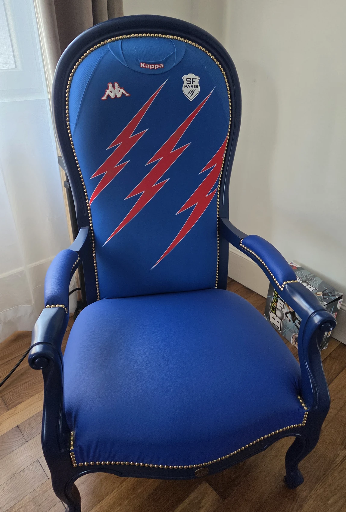 Fauteuil bleu du Stade Français Paris, orné d’éclairs roses et du blason du club.